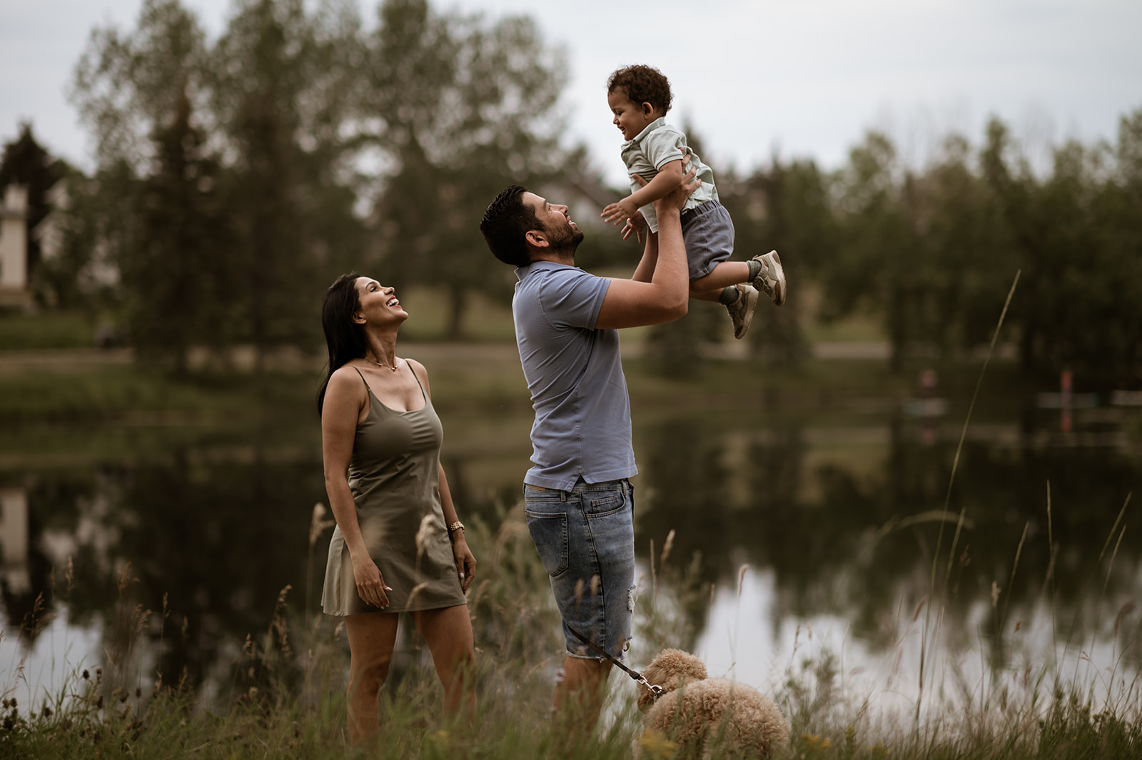 Calgary family photographer, parent holding a young child in soft window light